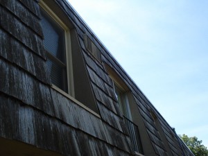  Old and damaged commercial vinyl siding on a townhouse before being replaced