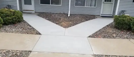Freshly poured concrete sidewalk offering clean, safe access to residential units.
